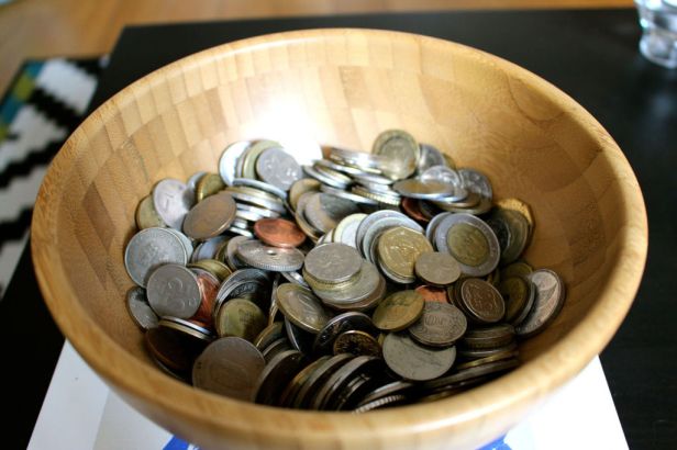 Muchas-monedas-en-un-cuenco-de-madera